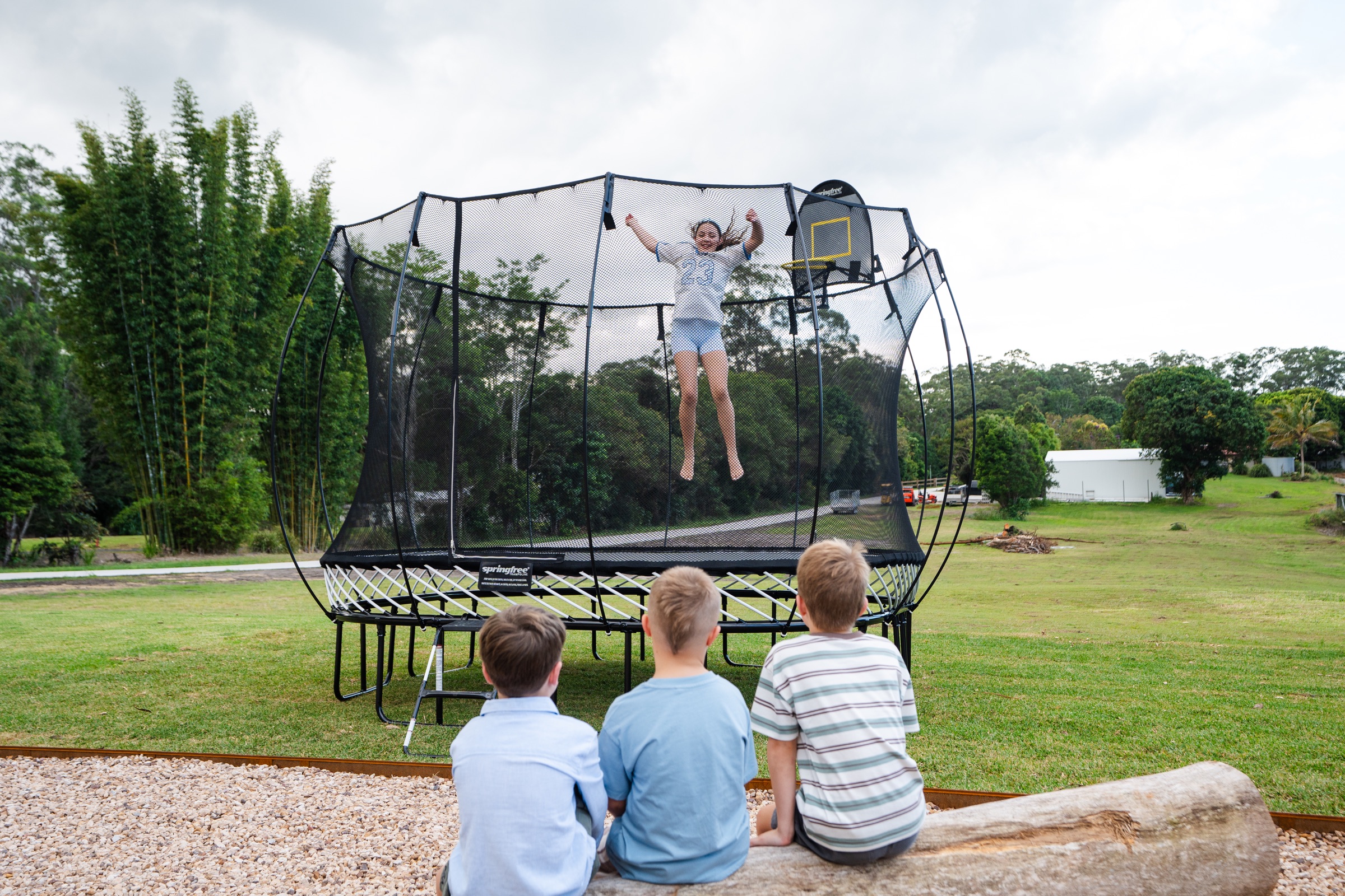 Children watching a Springfree trampoline lifestyle shoot
